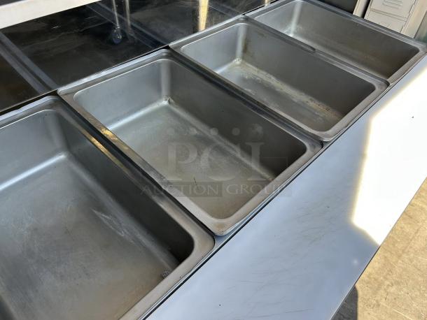 Avantco STE-4SA electric steam table with four open wells and undershelf, showing clean interior, tested and working.