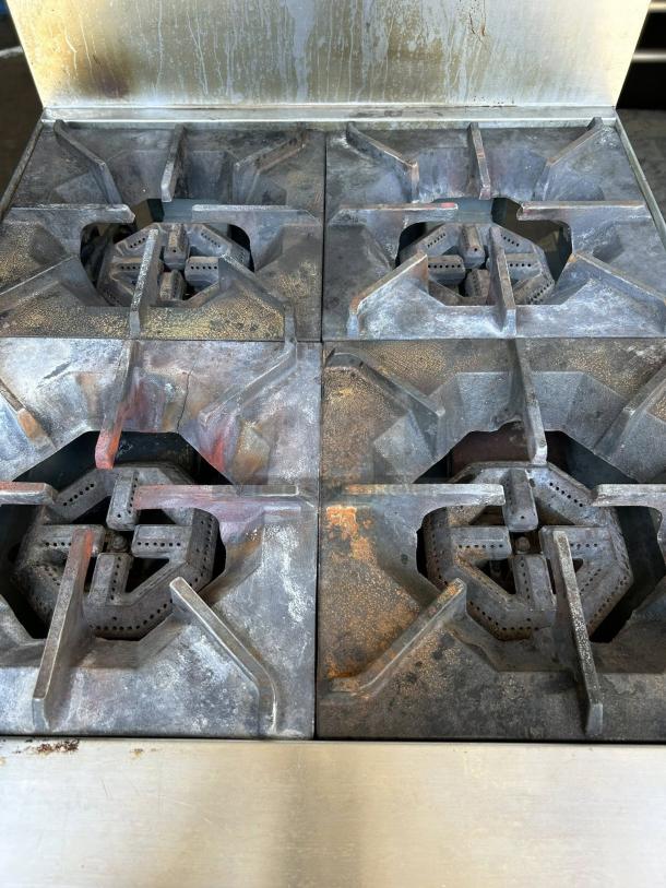 Cooler Depot TC-R24 commercial oven with 4 burners, tested and working. Visible wear on grates, stainless steel exterior.