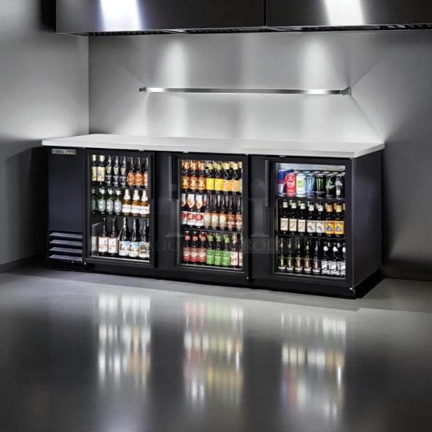 True TBB-4G 90 3/8" black glass door back bar refrigerator with LED lighting, in excellent condition, fully stocked with beverages.