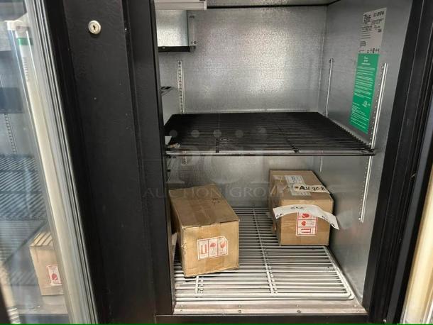 True TBB-4G-HC-LD back bar refrigerator with glass door, black finish, LED lighting, tested and working, interior view with shelving.