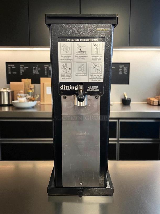 Ditting KR1203 commercial coffee grinder, excellent condition, operational, with visible operating instructions and contact info.