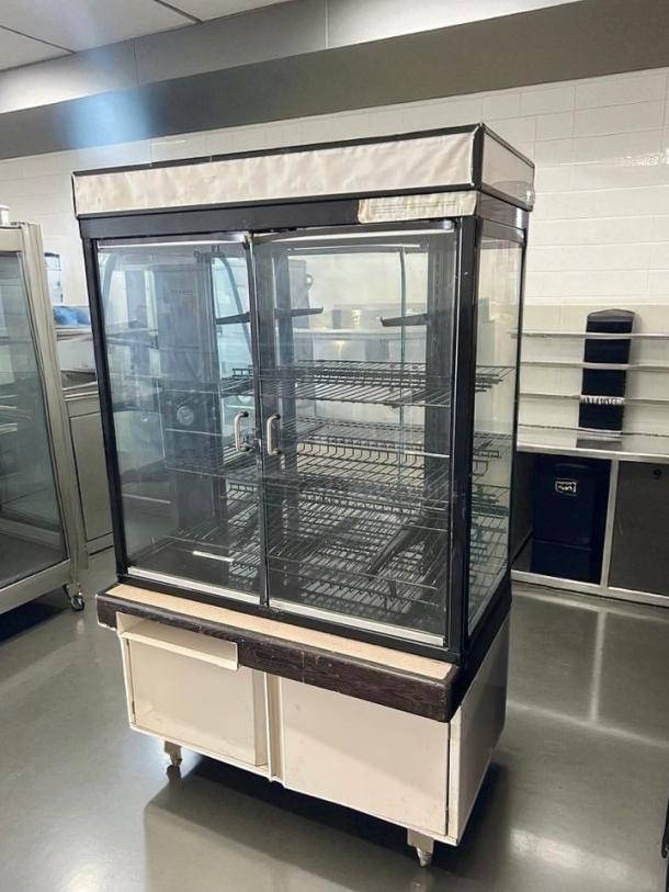 Hussmann dry bakery display case, excellent condition, glass doors, metal shelves, fully tested and working.