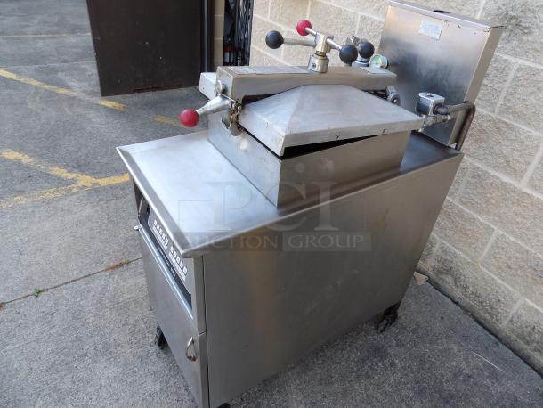 Henny Penny 600 stainless steel floor-style pressure fryer, excellent condition, natural gas-powered, 80,000 BTU on casters.