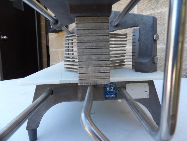 Commercial heavy-duty countertop tomato/vegetable slicer with an easy slice cutting board, visible NSF certification label, and sturdy metal legs.