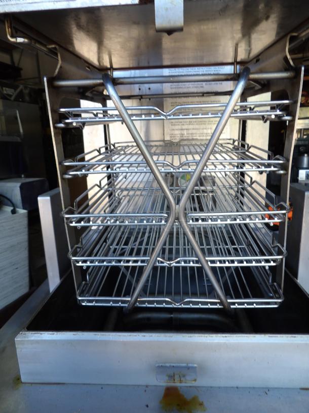 Henny Penny PFG-690 stainless steel commercial pressure fryer with filtration system, on casters, 100,000 BTU, interior view.