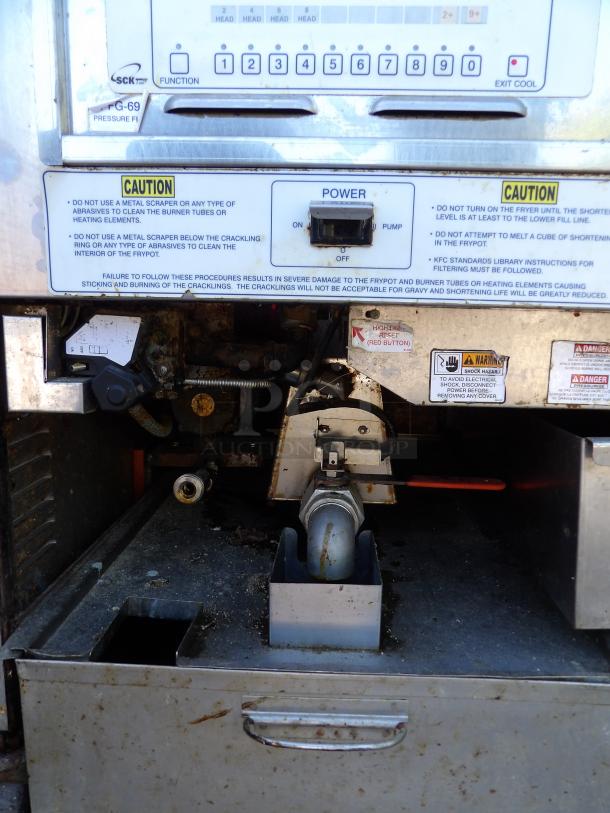 Henny Penny Model PFG-690 stainless steel pressure fryer, shows control panel and warning labels. Features filtration system, commercial casters.