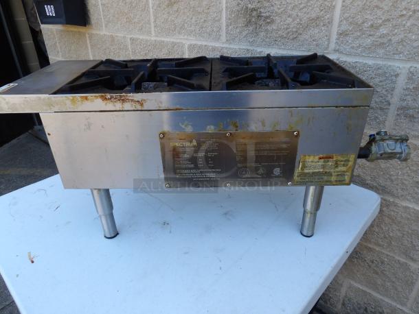 Spectrum NGH-2 stainless steel commercial 2-burner gas range. Dimensions: 12x27x15 inches. Used condition with visible wear.