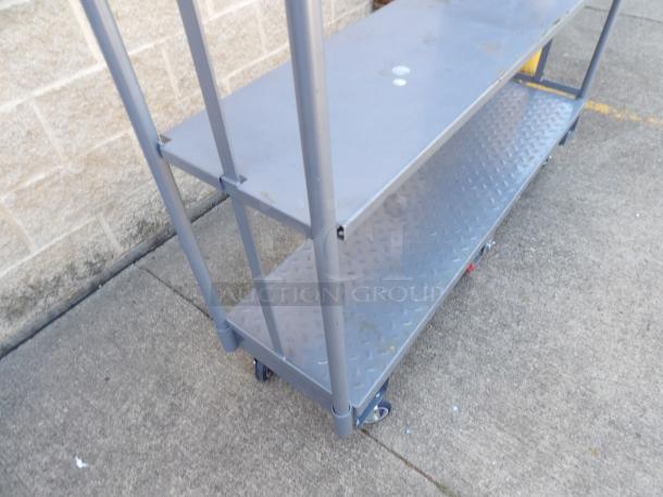 Regency 16" x 63" heavy-duty U-Boat utility cart with center brakes, metal construction, two-tier shelves, visible wear.
