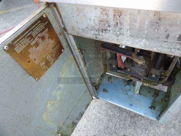 Patriot Natural Gas Deep Fryer FM-90-NG on casters, interior view showing gas connections and metal surface, moderate wear.