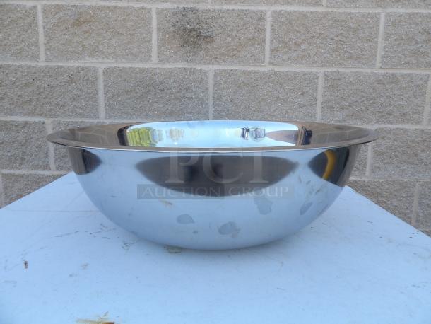 Stainless steel mixing bowl, 22-inch round x 7.5-inch, polished finish, minor surface marks, reflective surface.