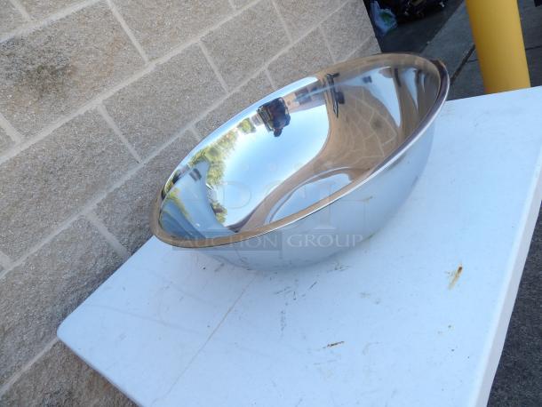 Stainless steel mixing bowl, 22-inch diameter, 7.5-inch height, round, shiny surface, minor scratches visible.