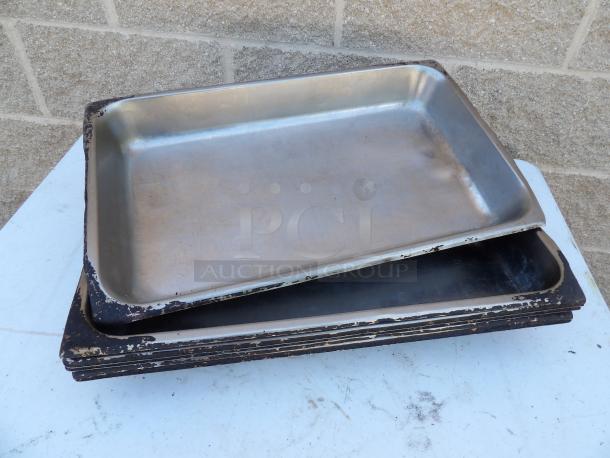 Stack of worn full-size 2 1/2" deep 24 gauge anti-jam stainless steel steam table pans. Signs of use on edges.
