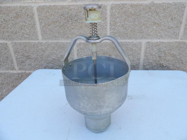Vintage metal donut/pancake dispenser with spring mechanism. Shows signs of wear. Ideal for collectors or bakers.
