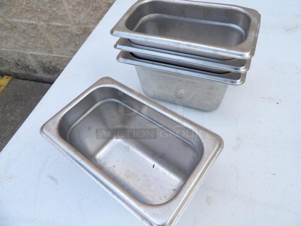 1/9 Size 4" Deep Anti-Jam Stainless Steel Steam Table Pans, 24 Gauge, stacked, showing minor wear.