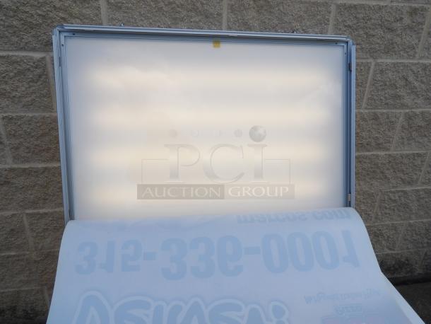 Two-sided lighted sign cabinet with a removable frame for ads. Powers on, great condition. Ideal for business use.