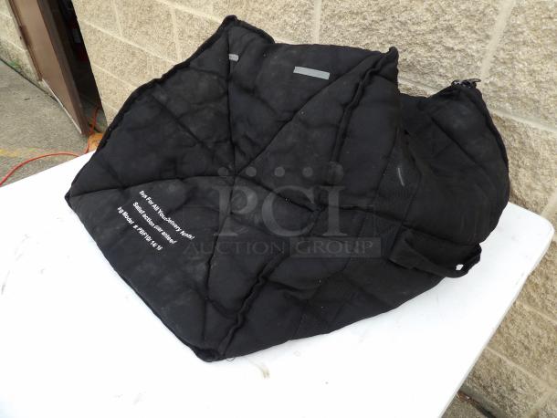 Black delivery bag PBF 10x14x16 on a table. Quilted exterior, visible text, used condition.