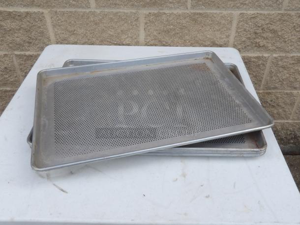 Full-size 19 gauge aluminum perforated bun pan, 18x26 inches, wire rim, used condition, shown on white surface.