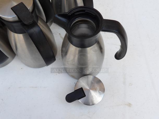 Classic Carafe 20 oz stainless steel insulated coffee server with black lid, minor wear visible, ideal for hot beverages.