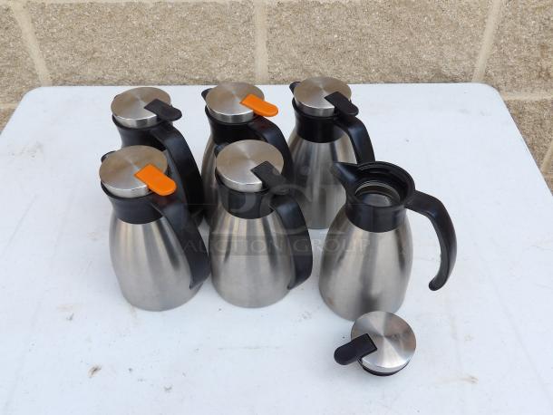 Stainless steel 20 oz. insulated coffee carafes with black and orange decaf lids, shown in a group.