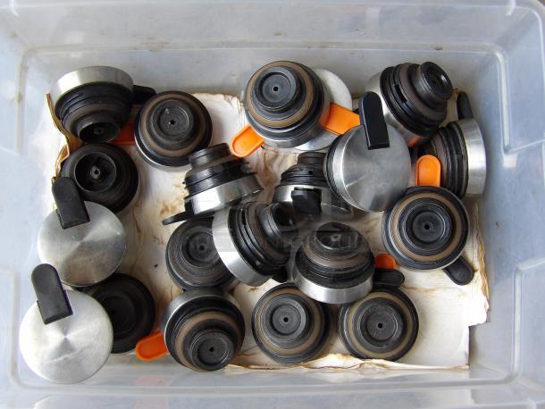 A box of assorted black and silver coffee carafe lids with black and orange spouts, used condition.