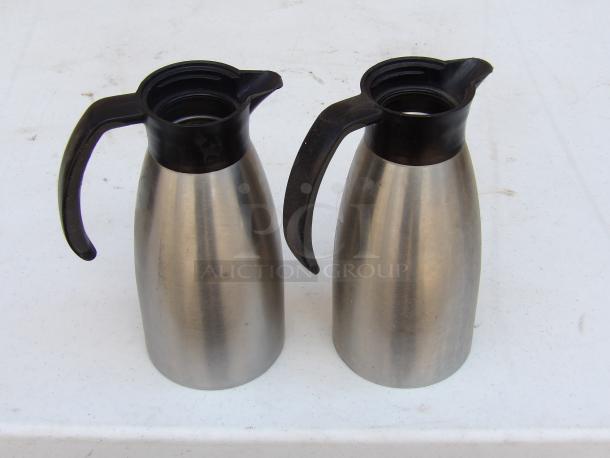 Service Ideas 33.8 oz stainless steel insulated coffee carafes with black lids. Minor wear visible.