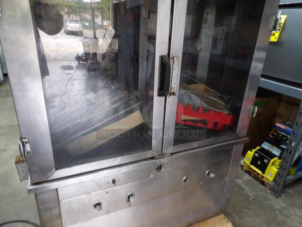 Late Model Rotisserie Gas Model 1545, stainless steel, 42x21.5x57.5 inches, double glass doors, 120 volts, visible wear.