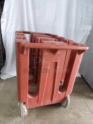 Cambro dish dolly caddy on wheels, red plastic, used condition, features multiple slots for dishes, embossed "Cambro" logo.