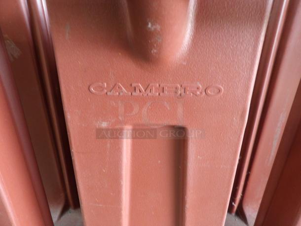 Cambro dish dolly/caddy, brown, embossed logo. Sturdy plastic. Used condition with visible scratches and scuffs.