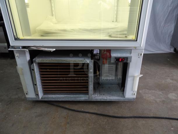 Standex BLG-27HD glass door freezer merchandiser, poly coated racks, powers on, cooling issue, model label visible.