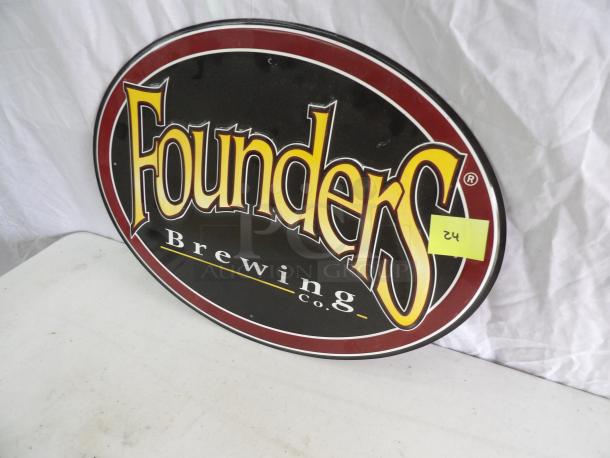 Oval Founders Brewing Co. sign, 20x15 inches, in good condition. Black with red border and bold yellow lettering.