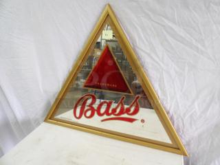 Triangular Bass mirror with gold frame, logo center. Dimensions 28x34 inches. Good condition, bold red branding.