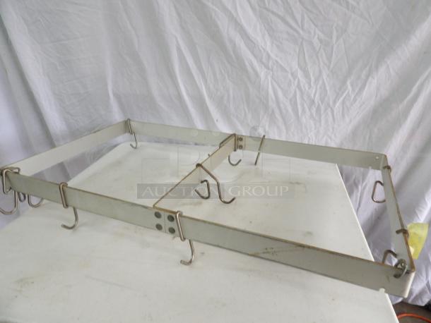 Aluminum hanging pot rack, 36x20 inches, features sturdy frame and multiple hooks. Slight wear visible. Ideal for kitchen use.