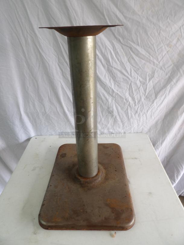 Metal table base with 9.5" square mounting platform, 16x22x28 inches, featuring a cylindrical column and rectangular base, shows surface rust.