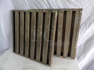 Two metal grease filters, measuring 19.5x20x1.5 inches, showing signs of wear, with visible rivets and slats.