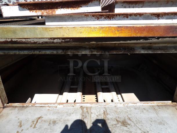 Blodgett stainless steel commercial pizza oven, single deck, 60,000 BTU, natural gas-powered, with pizza stones, visible wear.