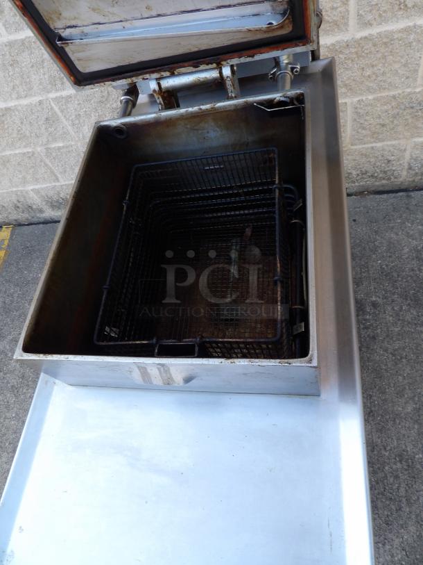 Henny Penny 8000 Computron stainless steel floor-style pressure fryer in excellent condition with metal fry basket and commercial casters.