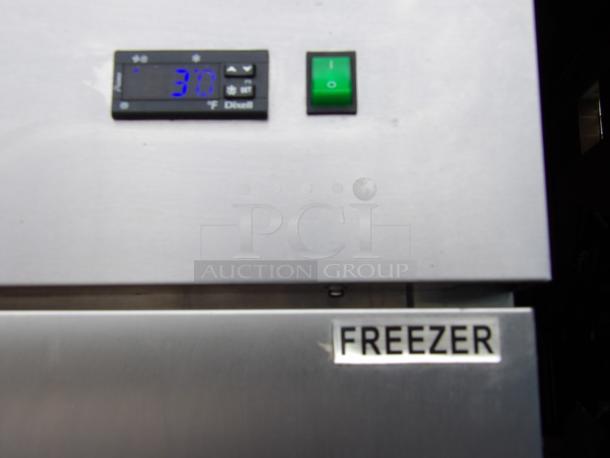 Arctic Air AF23 stainless steel freezer with digital display and green power switch. Label reads "FREEZER."