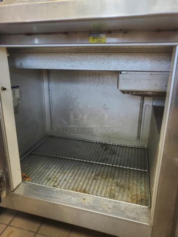 Nor-Lake ZF122SAS/0-2DQ 54" ice cream topping cabinet, stainless steel interior, visible wear, model label on top.