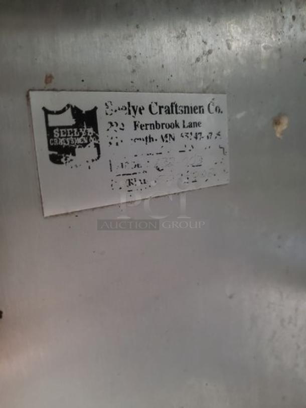 Stainless Steel Work Station by Seelye Craftsmen Co., worn label, shows address and branding, industrial-grade quality.