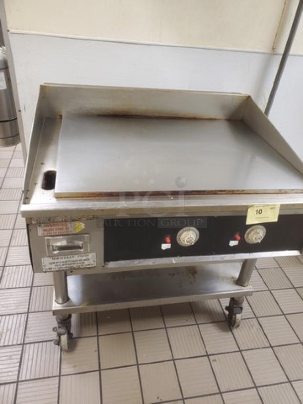 Miraclean natural gas griddle, stainless steel, dual control knobs, mounted on a wheeled stand, used condition.