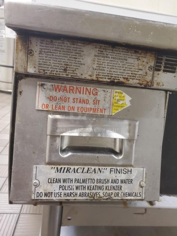 Miraclean Griddle, natural gas. Visible wear, instruction labels shown. Clean with brush and water; avoid harsh chemicals.