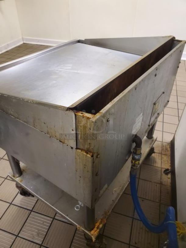 Miraclean natural gas griddle with visible signs of wear, large cooking surface, blue gas hose attached, robust metal construction.