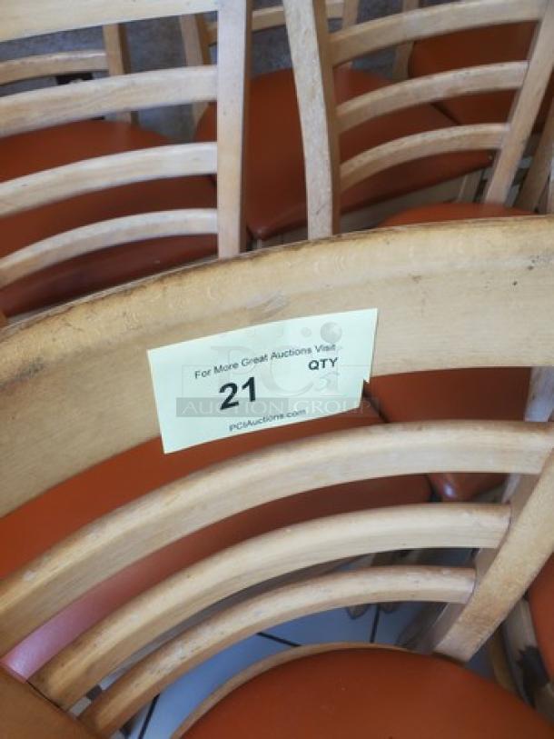 Lot of 5 wooden chairs with curved backs and orange cushioned seats. Auction tag indicates quantity and auction source.