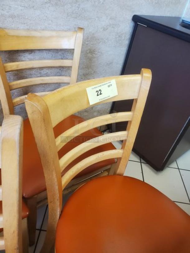Lot of 5 wooden chairs with ladder backs, orange seat cushions. Good condition, label shows quantity "22 Qty".