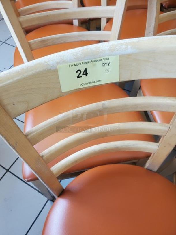 Lot of 5 wooden chairs with orange cushions; one cushion has a hole. Label indicates quantity "24" and "QTY 5".