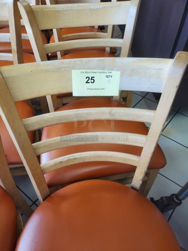 Lot of 5 wooden chairs with orange cushions, lightly used. Label indicates quantity 5, auction number 25.
