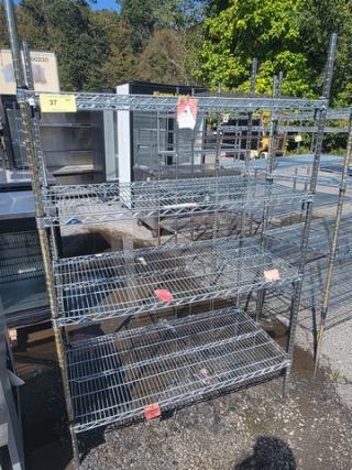 4-tier wire shelf in used condition, featuring adjustable shelves and robust metal construction. Ideal for storage solutions.
