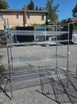 4 tier wire shelf, metal, sturdy construction, outdoor view. Adjustable shelves, good condition, suitable for storage.