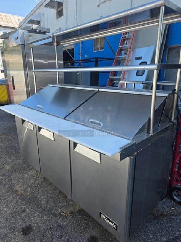 Migali C-SP72-30BT-HC sandwich/salad prep table with overhead shelf, stainless steel, three-door, excellent condition.