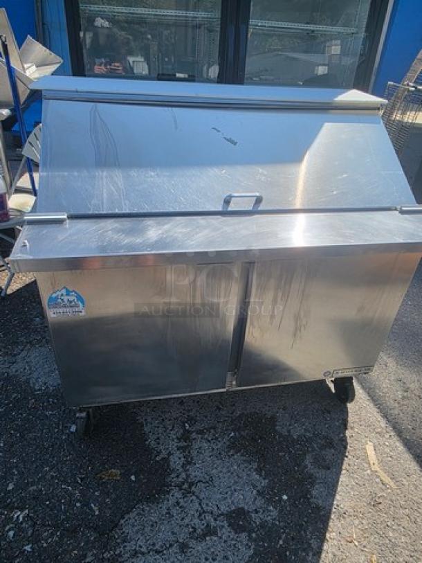 Beverage-Air SPE48HC-18M sandwich prep table, stainless steel, dual doors, on wheels, minor scratches, energy-efficient.